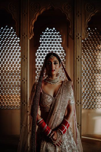 Photo of destination wedding bridal pose idea in ivory lehenga