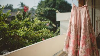 Photo of Pastel Pink Bride Lehenga with Floral Motifs on Hanger