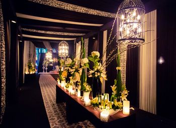 Photo of hanging birdcage with fairy lights and floral table centerpieces black and white theme cocktail