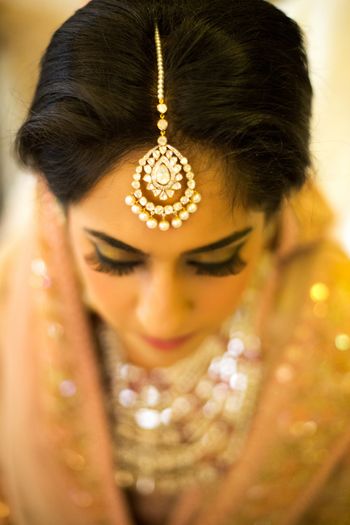 Bride Wearing Diamond and Pearl Maangtikka in Focus