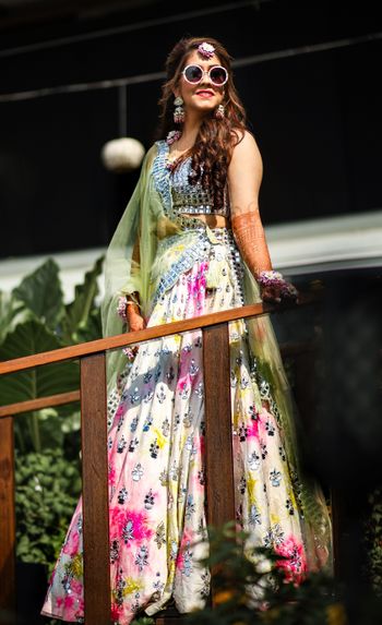 Bride wearing tie and dye lehenga with mirror work.