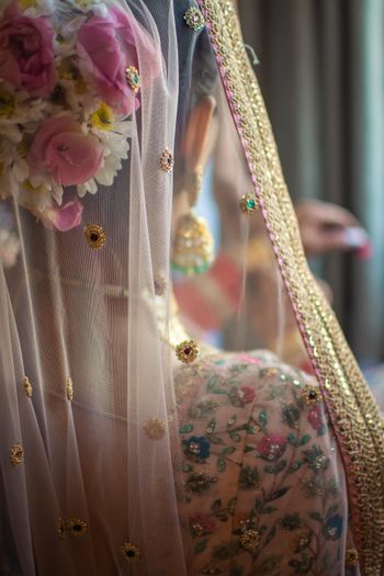 light pink bridal bun with pastel lehenga