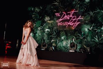 Photo of bride dancing with led quote in stage backdrop