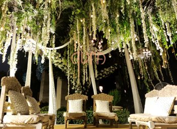 Photo of grand mandap with white seating and hanging floral strings