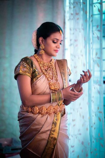 South Indian Bride wearing a white and green saree with temple jewellery.