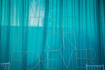 Blue curtain with quote written with wire