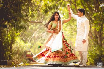 post wedding photoshoot bride twirling in red maroon velvet lehenga with green border