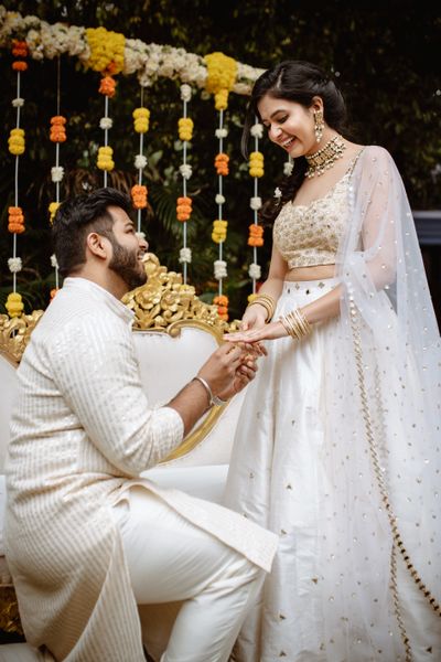 Photo of Bride and groom exchanging rings.