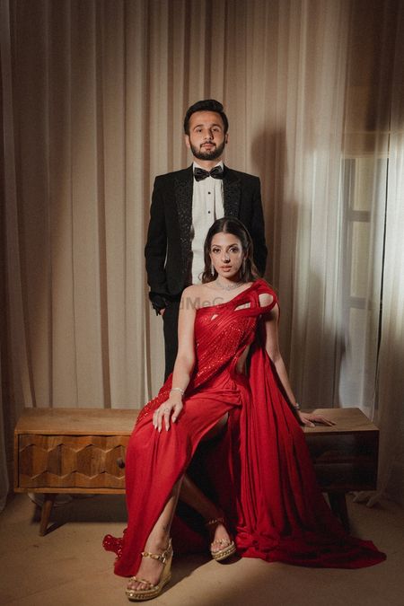 Elegant couple portrait with the bride in a stunning red structured gown and the groom in a tuxedo