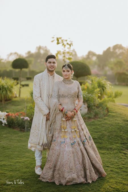 Lovely couple portrait with the bride in a pastel lehenga with peacock motifs