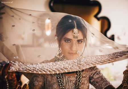 Photo of A bride getting ready, with a dupatta as a veil on her head