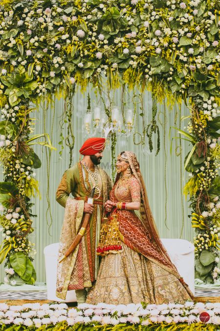 Coordinated bride and groom on stage decked up with unique floral arrangement