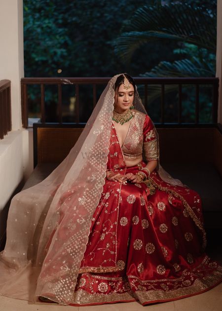 Stunning bridal portrait with a classic red and gold lehenga with a plunge neck blouse