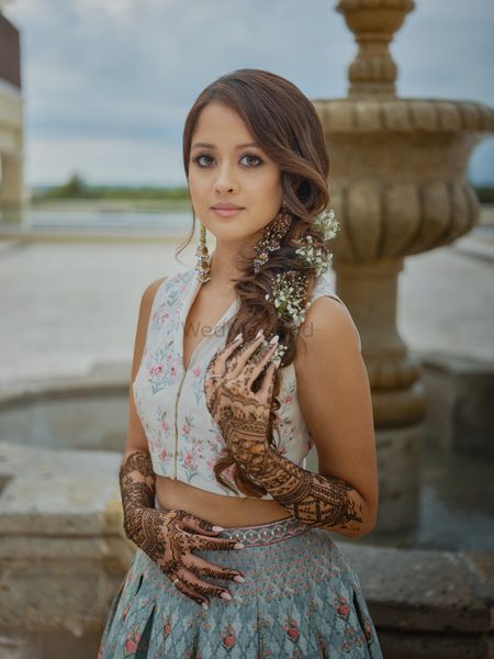 Photo of bride with soft and subtle mehendi makeup and side braid