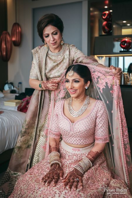 bride with mom placing her unique dupatta on head 