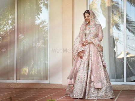 Photo of A bridal portrait with the bride in a peach floral Sabyasachi lehenga