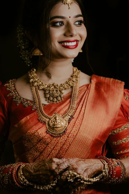 south indian bride with layered temple jewellery necklaces