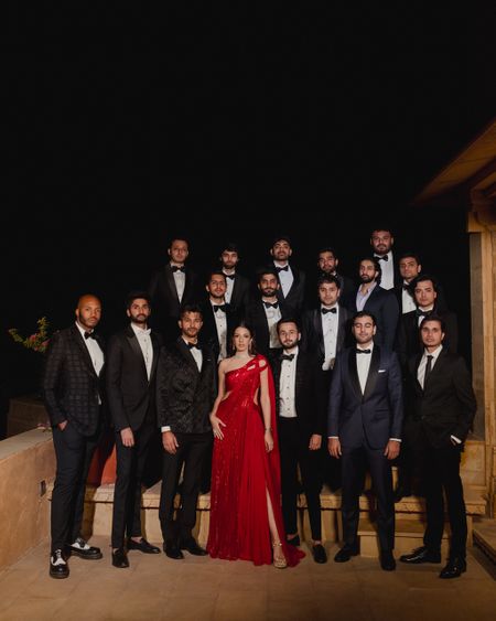 Group shot of the bride and the groom with all the groomsmen in black tuxedos