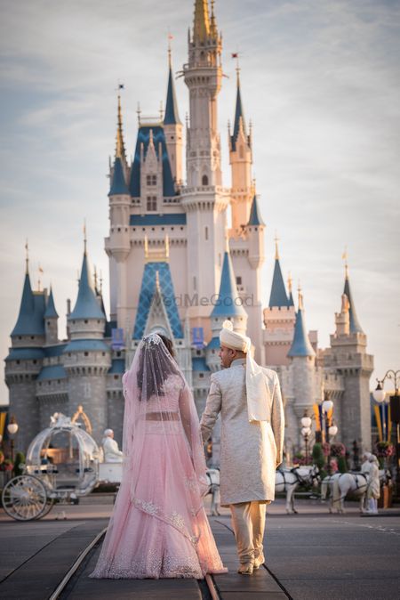 Bride and groom pose infront of Disney World castle at Orlando