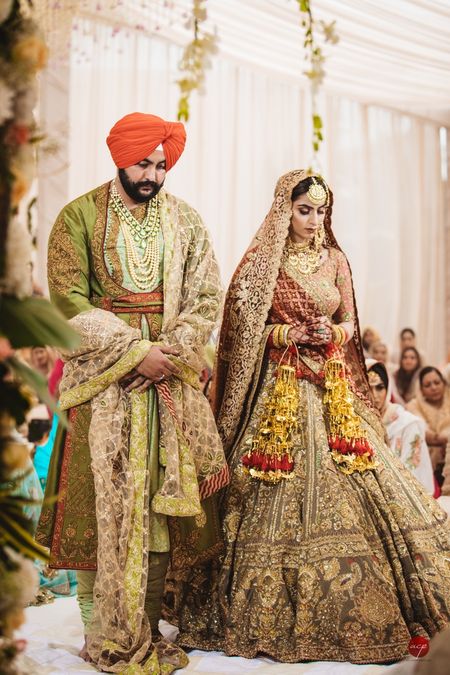 A Sikh bride and groom in coordinated, vintage-looking outfits