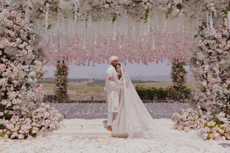 Lovely all-white themed outdoor wedding portrait with the couple in coordinated outfits