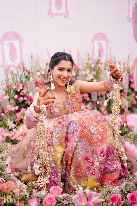 Photo of Fun bridal portrait on the haldi day surrounded by lovely pink decor