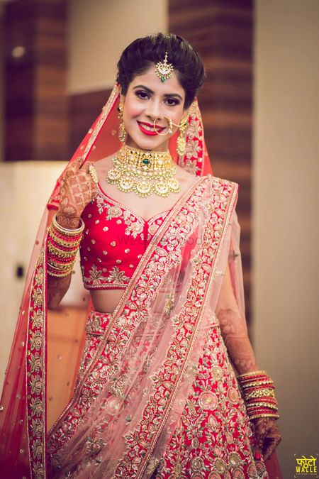 Photo of Bridal lehenga in red and pink with choker necklace