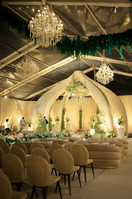 Lovely all-white mandap with florals and crystal chandeliers