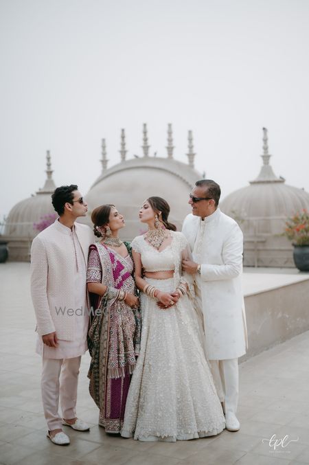 Photo of Fun family portrait of the bride with her family on the wedding day