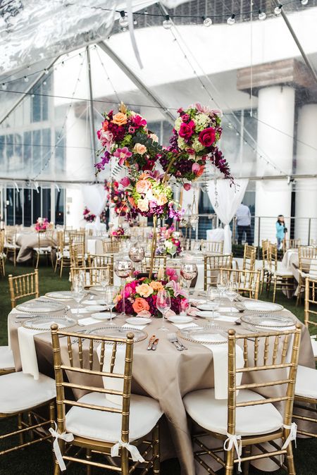 Gold table setting with giant floral centrepiece 