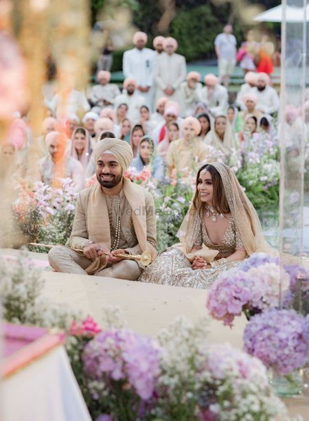 smiling couple in gold-toned coordinating outfits at anand karaj 