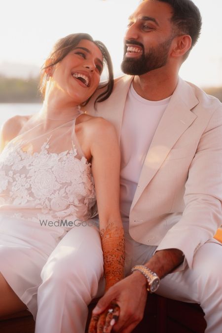 Photo of Stunning couple portrait captured in a candid moment with the bride in a fun lace white dress and the groom in a white tuxedo.