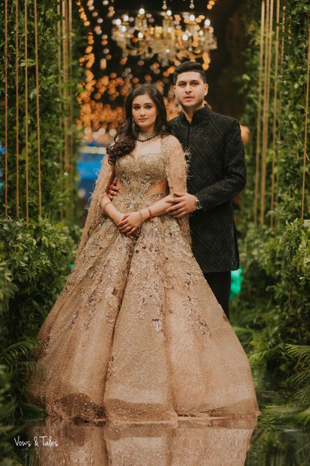 Stunning couple portrait with bride in a gold gown with cut out detailing and cape sleeves!
