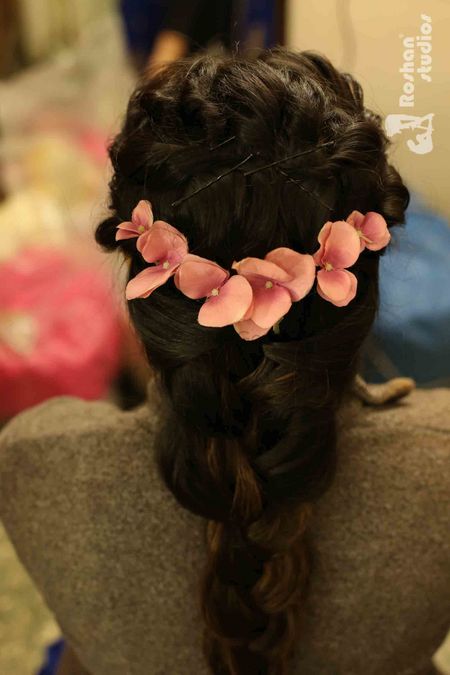 Photo of Mehendi hairdo with flowers for curly hair