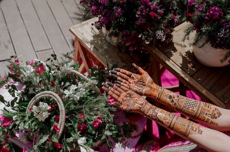 Photo of Bridal Mehendi with personalized elements shot around pretty floral décor.