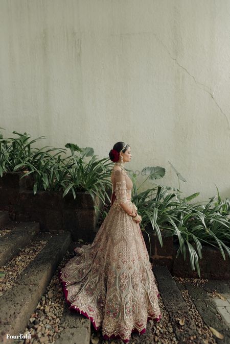 Stunning lehenga with bride in a bridal bun with red carnations