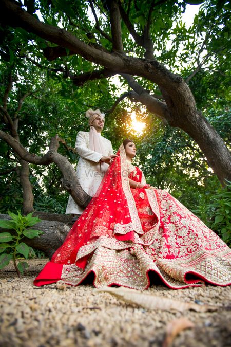Photo of Unique couple shot with the bride in a red lehenga