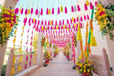 mehendi entrance decor idea with tassels and florals