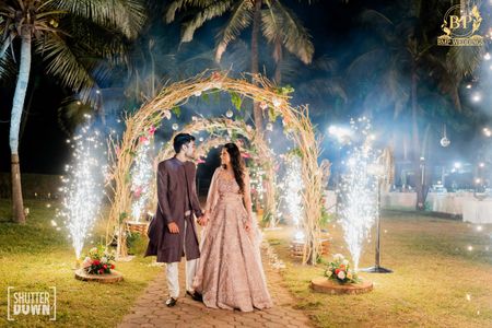 couple walking through entrance arch and sparklers on the side