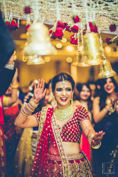 Bride dancing and entering under phoolon ki chadar with bells