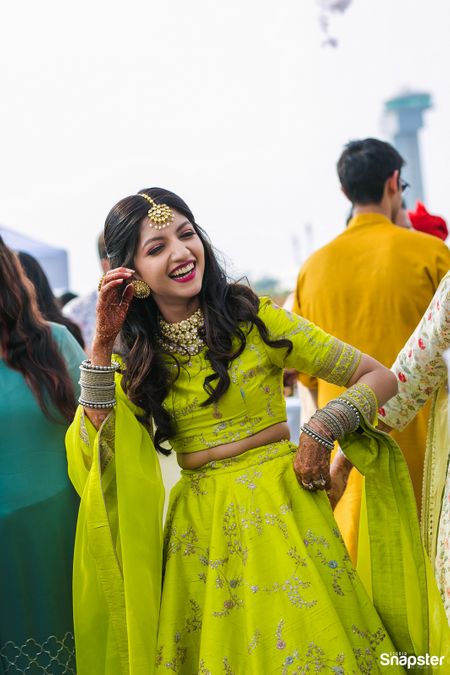 A bride to be in green dancing on her mehndi function