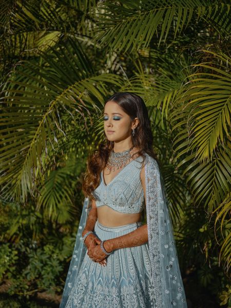 bride with metallic blue eye makeup for sangeet