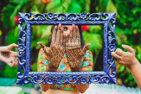 Photo of Mehendi hands inside blue frame