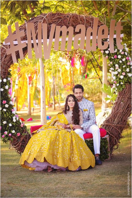 Mehendi couple seat with wedding hashtag