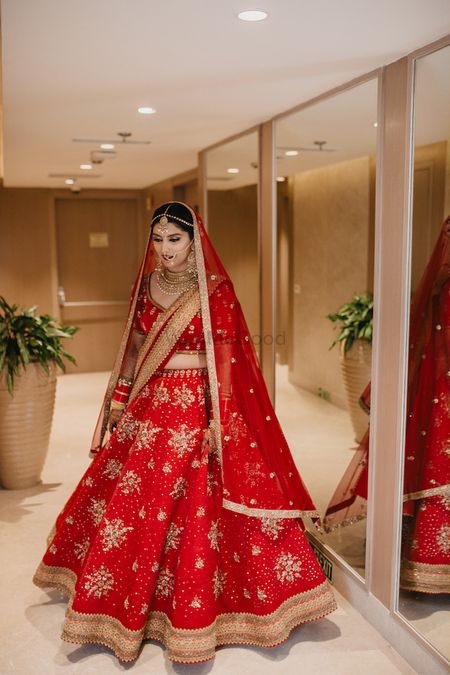 Photo of A bride in red lehenga twirling