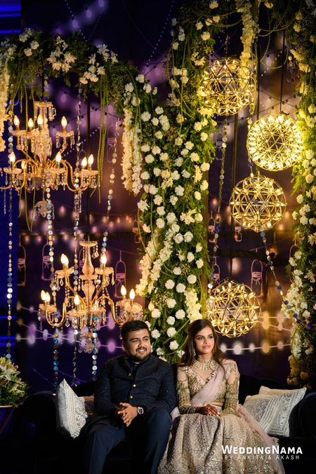 Photo of sangeet photobooth stage with chandeliers and lights