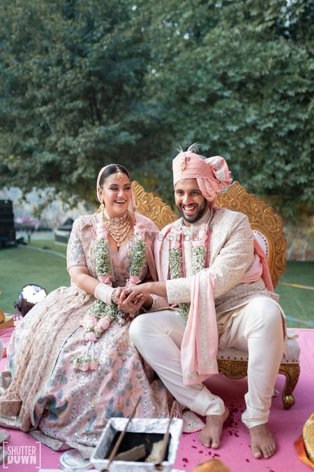 Photo of Bride & groom in pastel wedding outfits