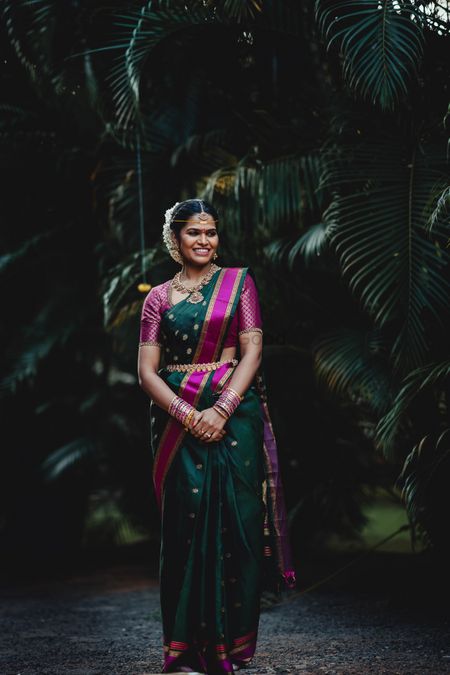 South indian bride wearing a dark green and purple kanjivaram saree on her wedding