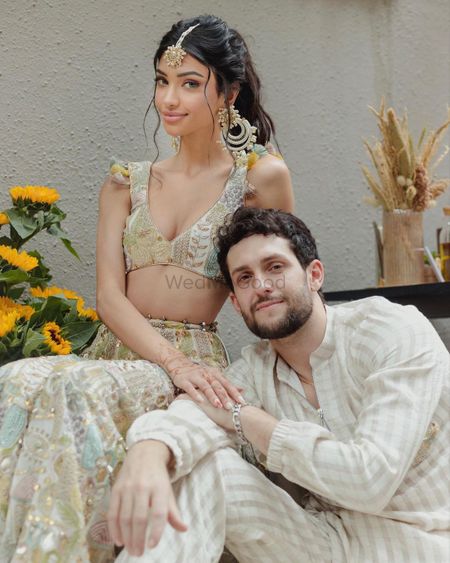 Photo of Alanna & Ivor in pastel outfits on their Haldi