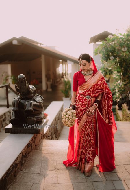 Lovely all-red bridal look with Sabyasachi red saree and a waist belt